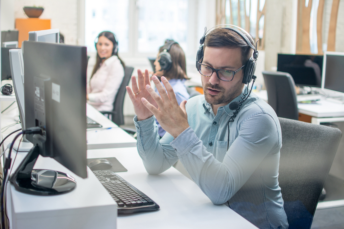 Young,Handsome,Male,Technical,Support,Agent,Trying,To,Explain,Something Corporate travel management agent talking on the phone